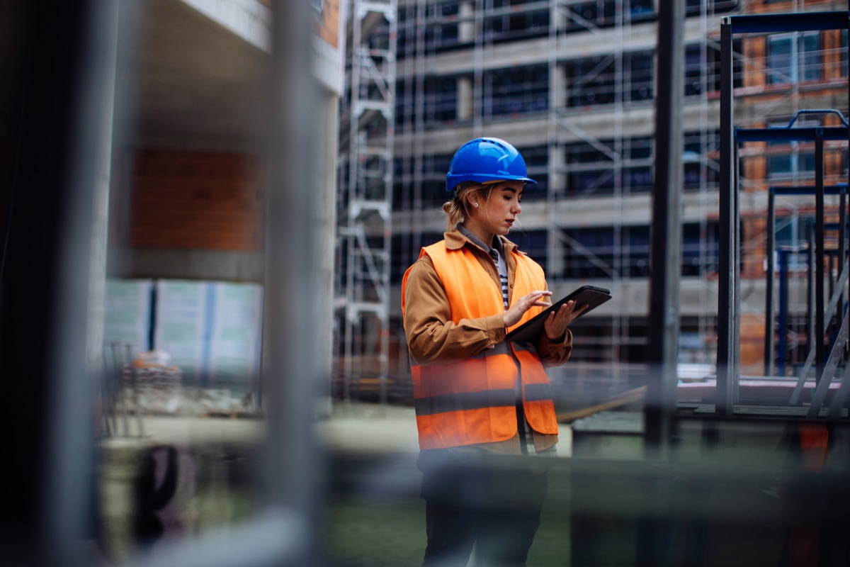 Construction professional reviewing plans on a tablet at a jobsite