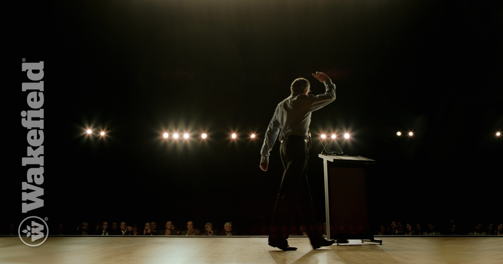 Man walking onto a dark stage with spotlights